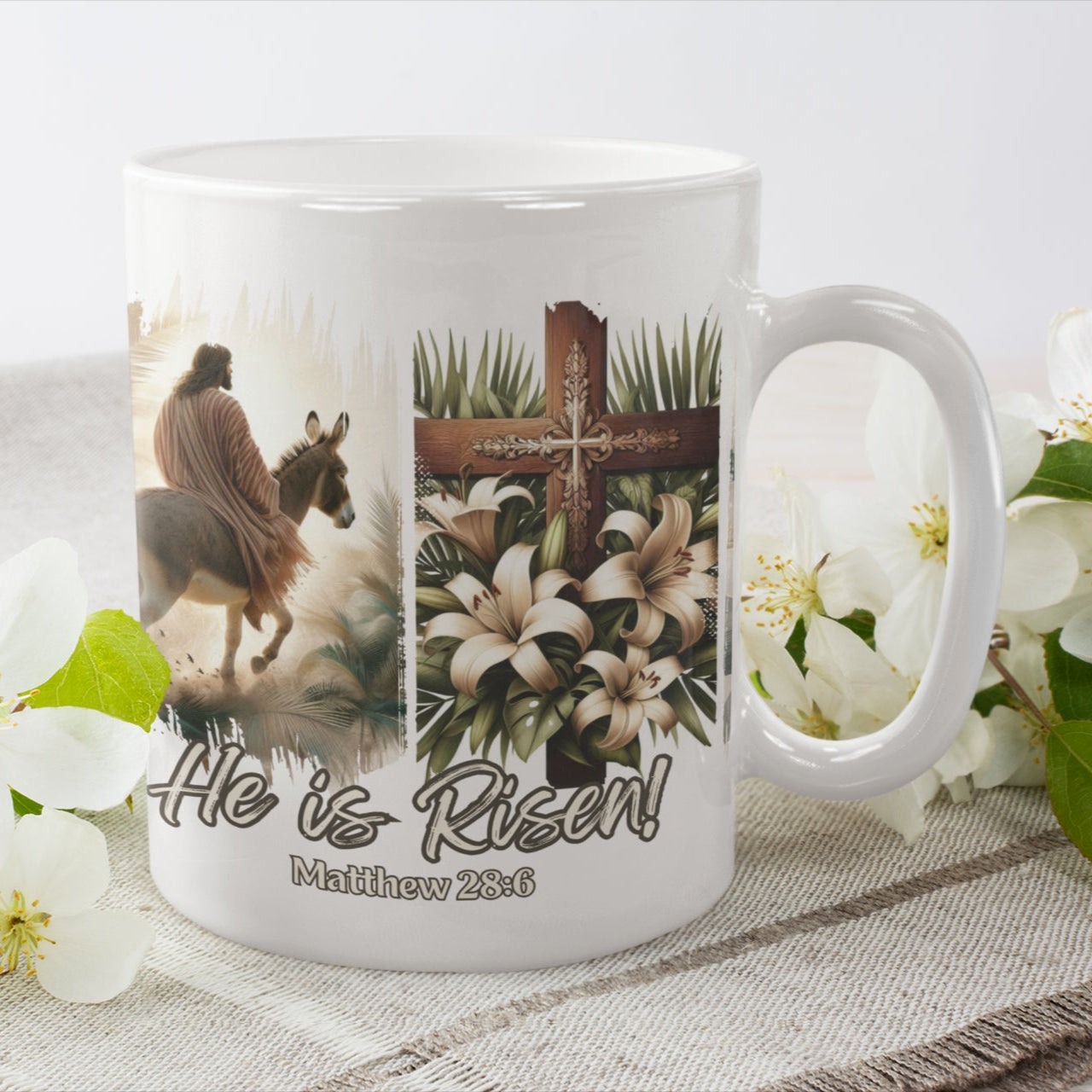 White 11oz coffee mug with a depiction of Jesus riding a donkey, a detailed cross adorned with lilies, and elegant floral touches, all set against a dramatic black brushstroke backdrop.