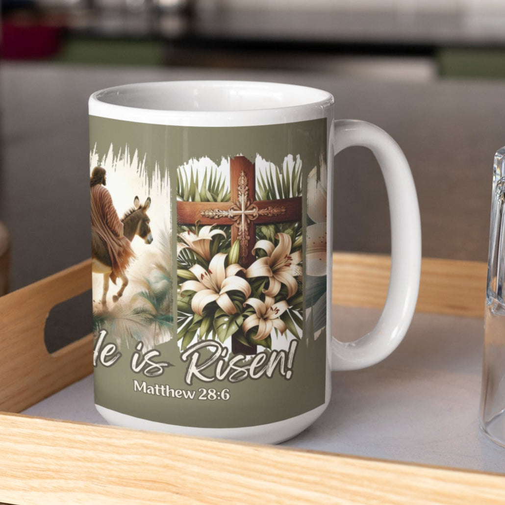 Easter Olive 15oz coffee mug with a depiction of Jesus riding a donkey, a detailed cross adorned with lilies, and elegant floral touches, all set against a dramatic black brushstroke backdrop. Also features the words He is Risen! and the Bible verse Matthew 28:6 at the bottom of the mug.