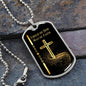 Child of God Man of Faith dog tag with gold cross and black background and silver ball chain positioned on gray rock.