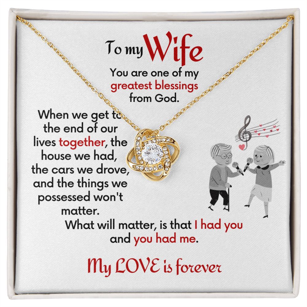 To Wife 18k yellow gold finish Love Knot necklace with jewelry message card. Card features special message to wife with an elderly man and woman singing together. Card is white background.