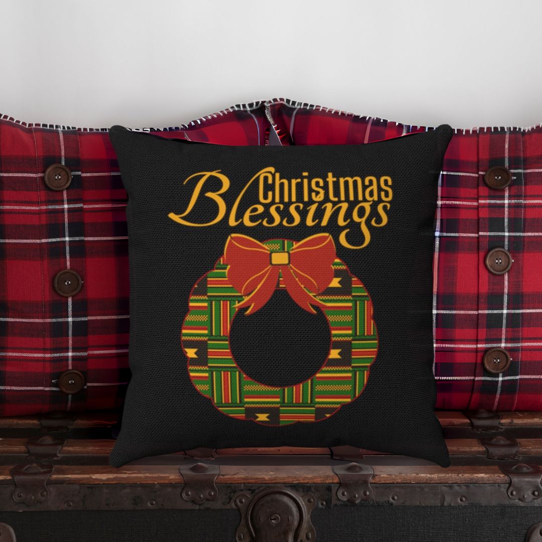 Decorative pillow with 'Christmas Blessings' text and wreath design on a Kente cloth background.