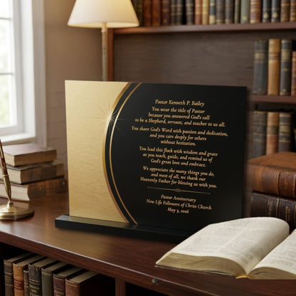 Pastor appreciation decorative plaque with printed text on a black and gold background and a black acrylic stand. The plaque is sitting on a wooden bookshelf with other bookshelves in the background.