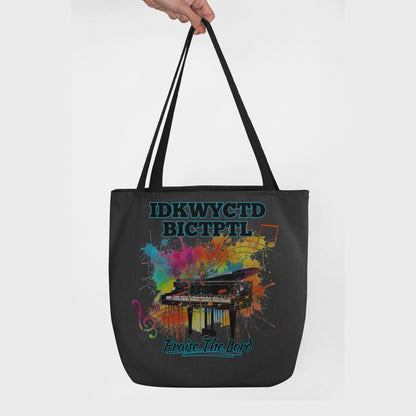 Black tote bag with a colorful piano design and text KWYCTDBICTPTL - Praise the Lord on a white background.