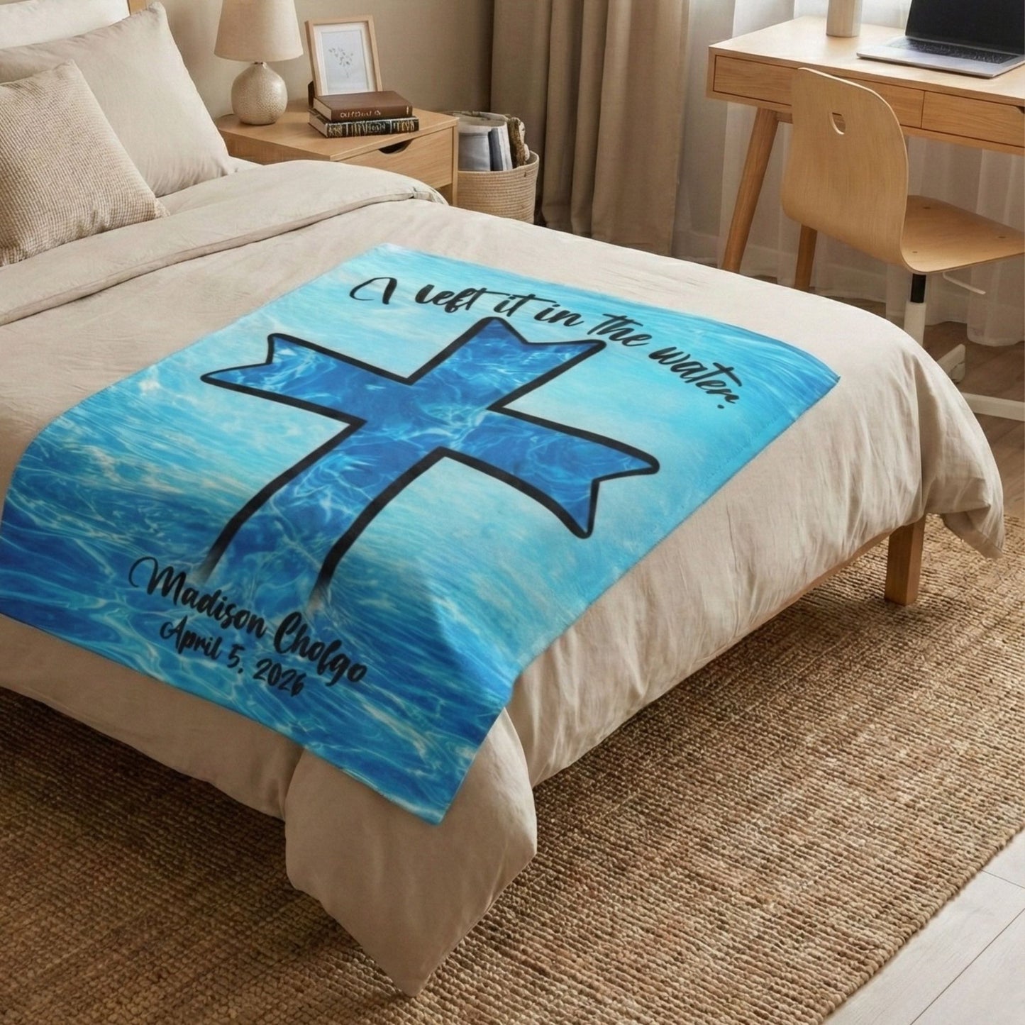 Blue blanket with a cross in the water design on a bed in a bedroom setting