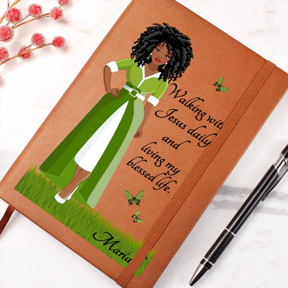 Printed image of an African American Woman with Christian quote on the front cover of a light brown vegan writing journal. Christian quote says, "Walking With Jesus daily and living my blessed life." Also has images of green butterflies and a place at the bottom for personalizing with a name.