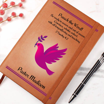 Vegan Leather Writing Journal for a female minister.  Features a fuchsia dove with a twig in it's beak and the Bible verse 2 Timothy 4:2. The words Preach The Word as well as the personalized name of the pastor is in bold letters.