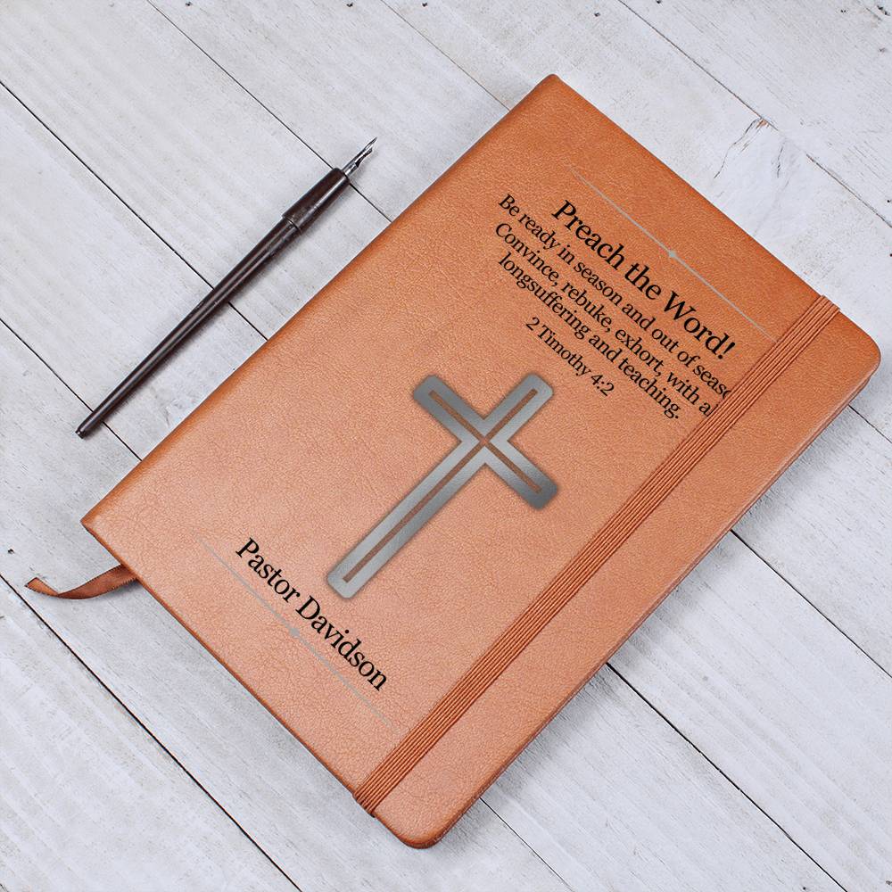 Brown vegan leather writing journal with a silver cross on the front cover.  Front cover also features Bible verse 2 Timothy 4:2 as well as a place to personalize a name underneath the cross. Bible scripture is printed in black.