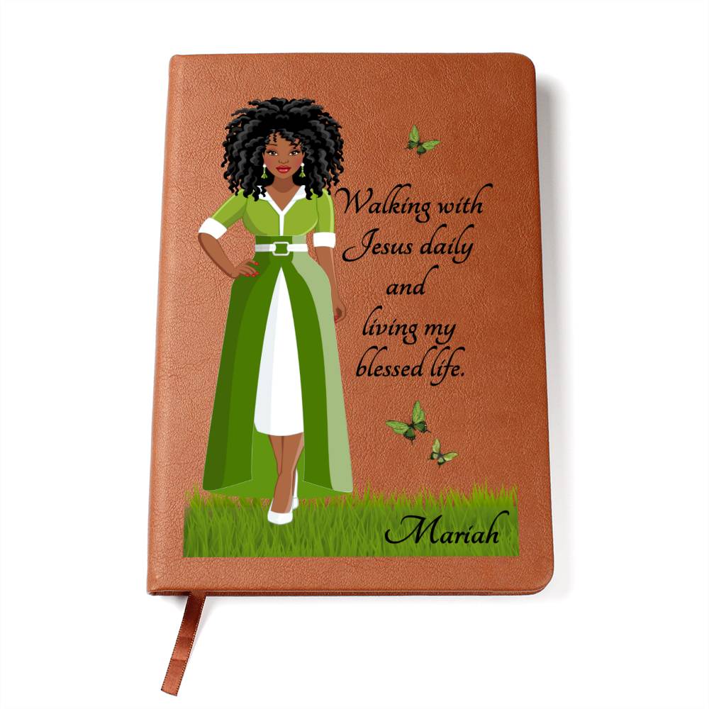 Art of African American Woman with Christian quote on the front cover of a light brown vegan writing journal. Christian quote says, "Walking With Jesus daily and living my blessed life." Also has images of green butterflies and a place at the bottom for personalizing with a name.