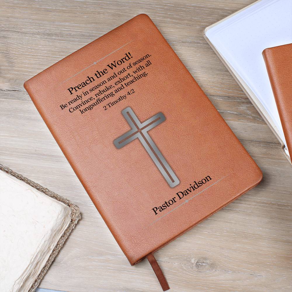 Vegan leather journal with a silver cross, Bible verse 2 Timothy 4:2 as well as a place to personalize a name underneath the cross. Bible scripture and name is printed in black.