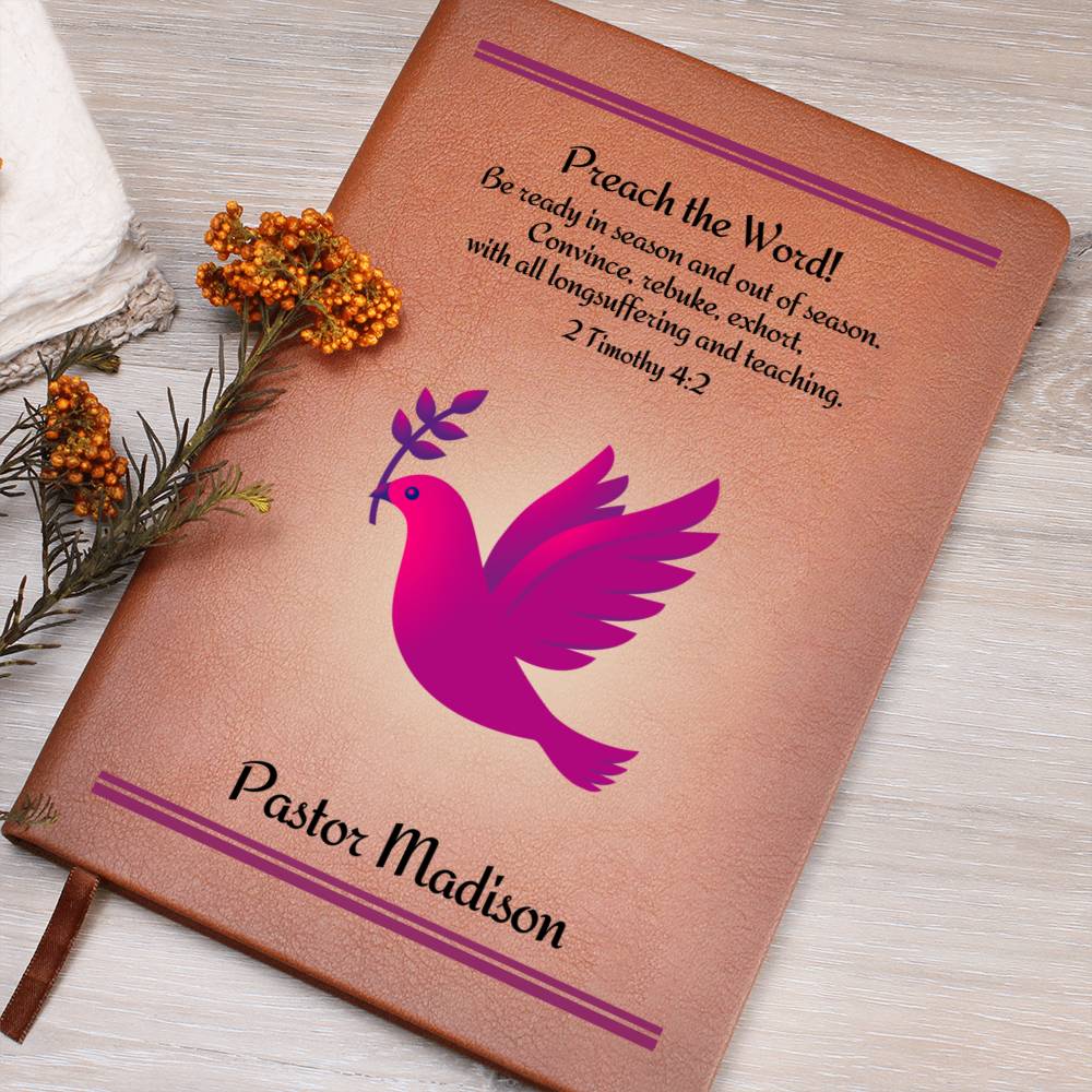 A brown leather writing journal for a female pastor.  The journal features on it's cover a fuchsia dove with a twig in it's beak and the Bible verse 2 Timothy 4:2. The words Preach The Word as well as the personalized name of the pastor is in bold letters.