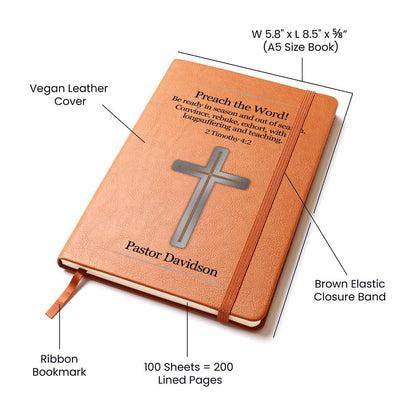 Image is of the cover of a brown vegan leather writing journal. Features of journal are displayed.  Cover has a silver cross, Bible verse 2 Timothy 4:2, and a place to personalize a name underneath the cross. Bible scripture is printed in black.