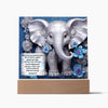 Silver 3D elephant image print with 3D flowers on an acrylic plaque that sits on a wooden base. Elephant is beautifully designed with swirled detail is in front a beautiful blue swirled background. Decorative plaque also features Bible verse Joshua 1:9.