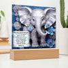 Load image into Gallery viewer, Image of a silver 3D elephant print with 3D flowers on an acrylic plaque that sits on a wooden base. Elephant is in front a beautiful blue swirled background and also features Bible verse Joshua 1:9.