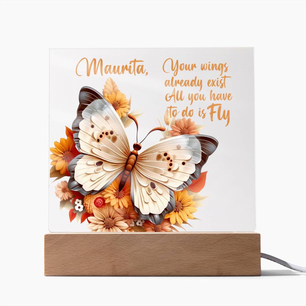 Printed image of a beautiful 3D butterfly in the colors of tan, beige and gray.  Butterfly is surrounded by orange, yellow, peach, and tan flowers on a clear acrylic plaque. Plaque sits in a light brown wooden base. Also features a place to personalize name along with a message of encouragement. That reads, Your wings already exist All you have to do is fly.