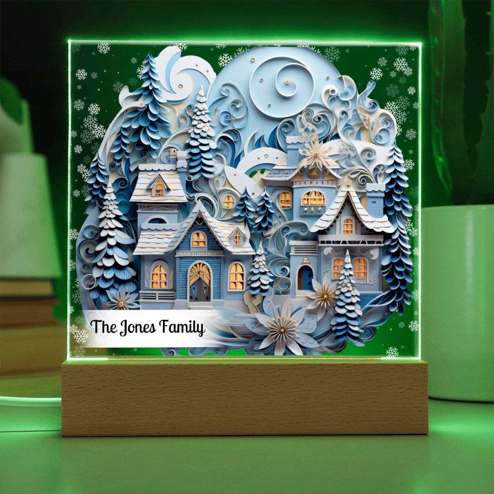 Image of 3D winter village printed on an acrylic plaque that sitting on a green LED light base.