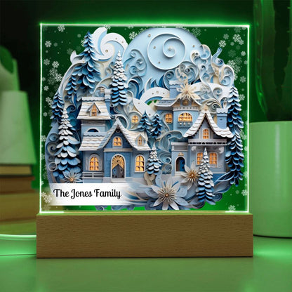 Image of 3D winter village printed on an acrylic plaque that sitting on a green LED light base.
