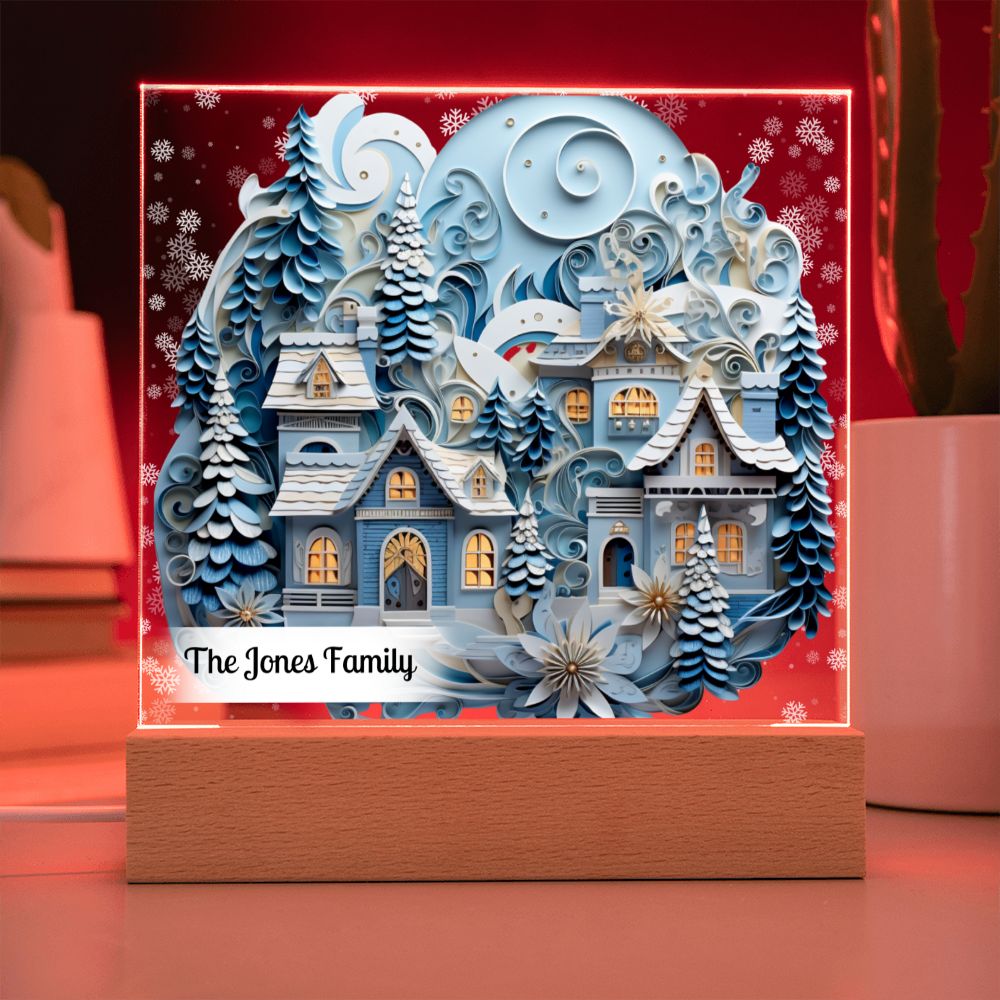 Image of 3D winter village printed on an acrylic plaque that sitting on a red LED light base.