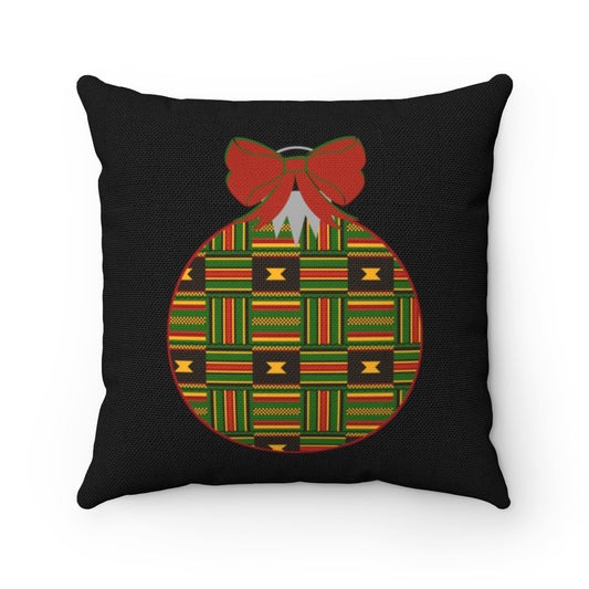 A black throw pillow with a Christmas ornament design featuring the Kente pattern in colors green, yellow, and red.