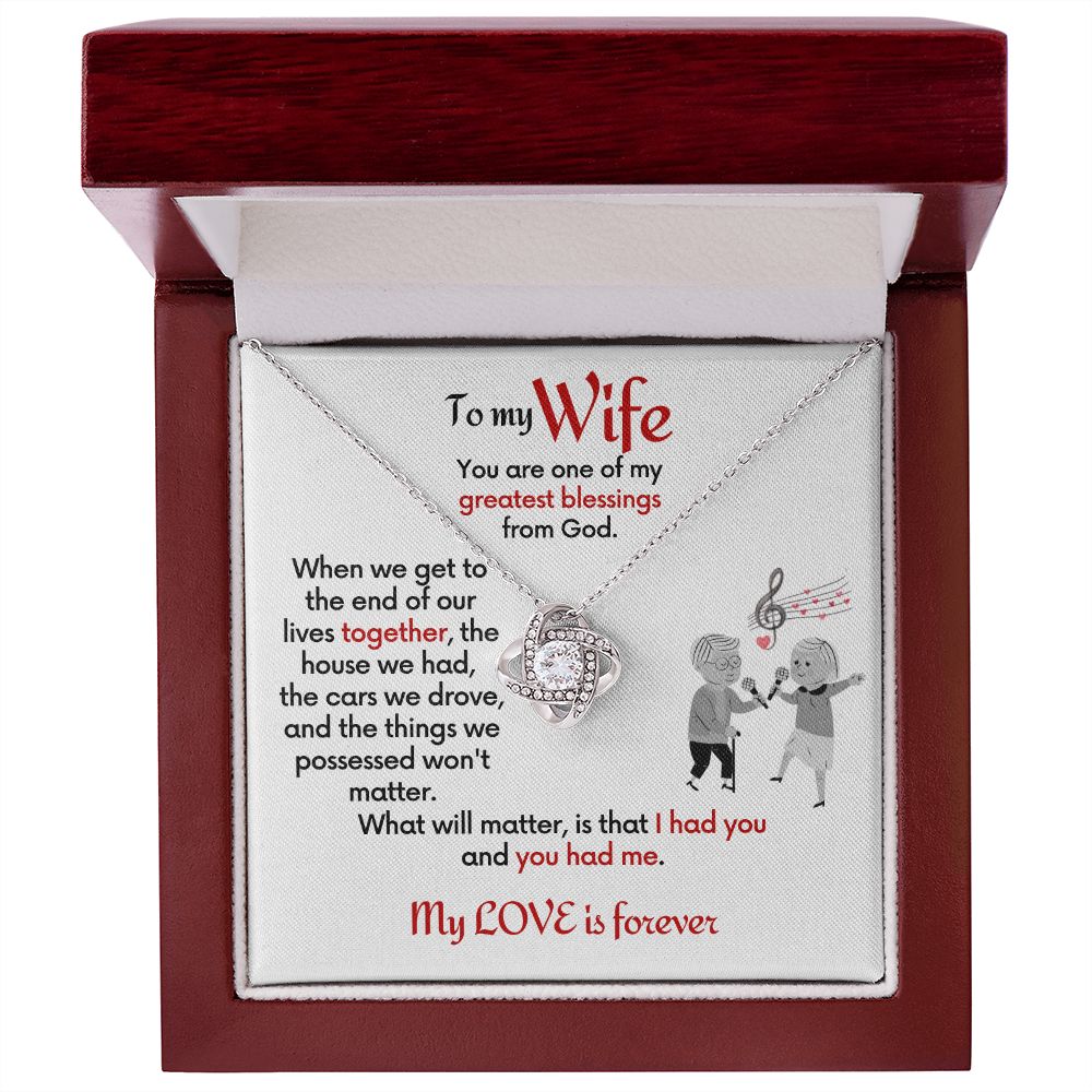 To Wife Love Knot necklace with jewelry message card. Card features special message to wife with an elderly man and woman singing together. Card is white background. In mahogany box with LED light.